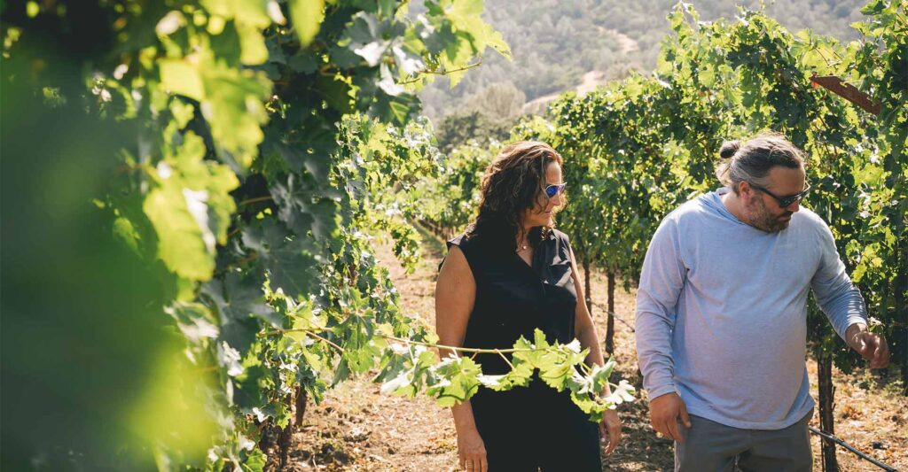 Founder, Allison, and Winemaker, Kieran, walking through vineyards
